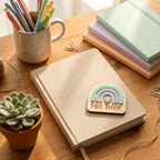 Notebook with a personalized wooden name tag on a desk with stationery items.