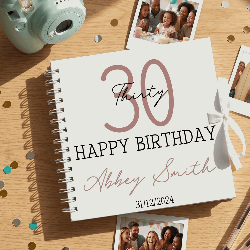 Personalised birthday album with '30 Happy Birthday Abbey Smith' on a wooden surface with photos and a camera.