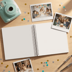 Open album with photos of a birthday celebration on a wooden surface with a camera and confetti.
