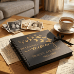 Memorial book with butterfly design on a table with photos and a cup of tea.