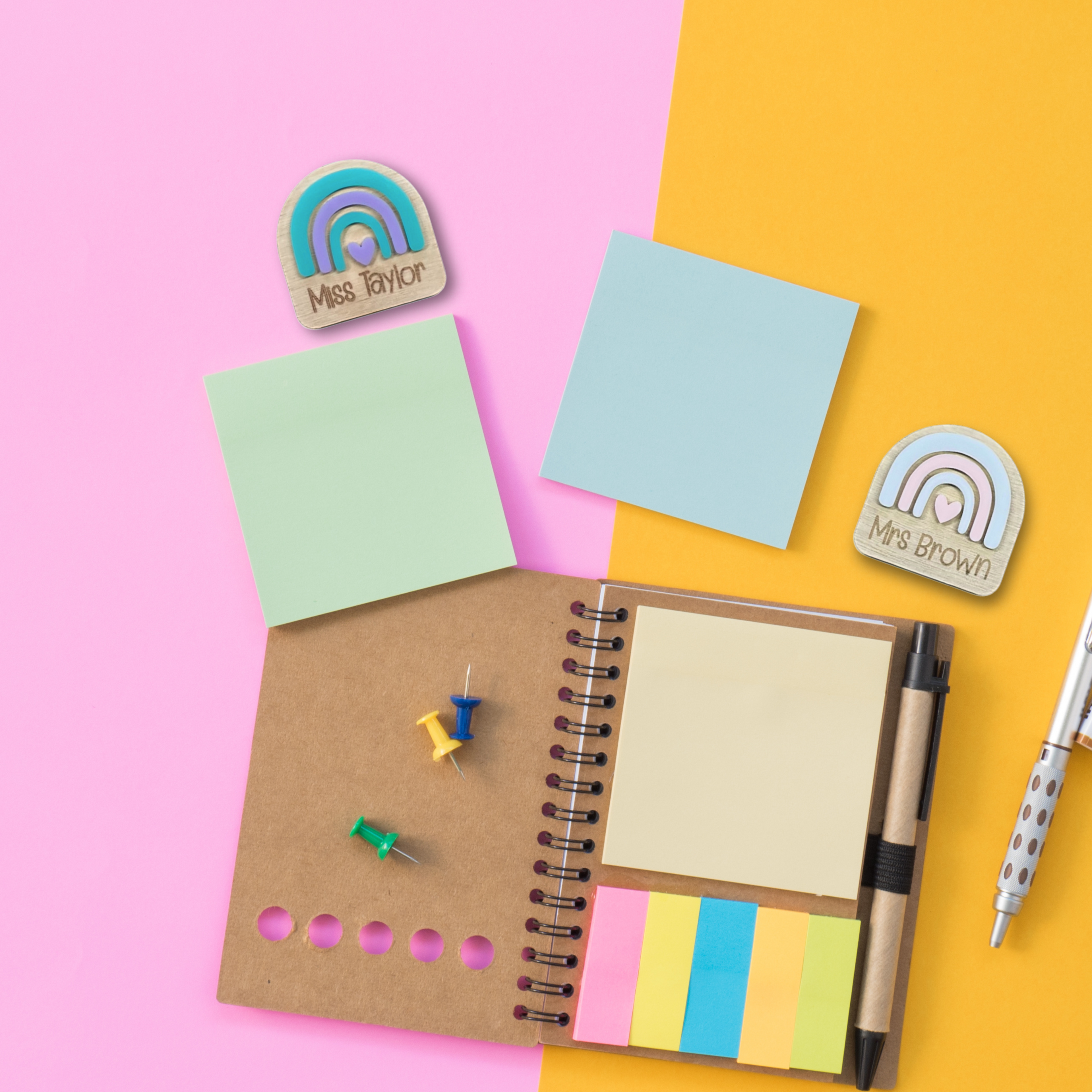 Flat lay of two rainbow name badges with engraved teacher names