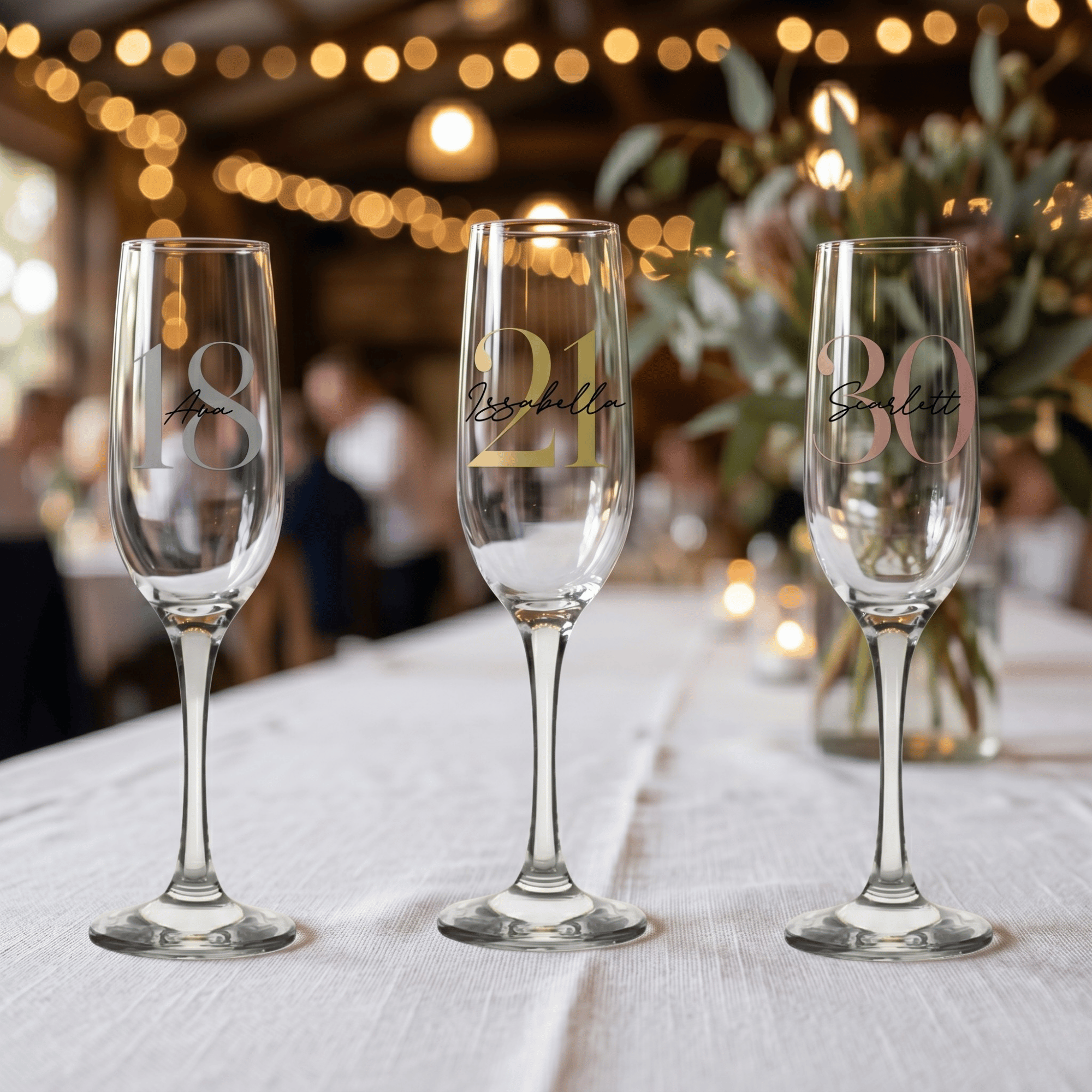 Three champagne flutes with personalized numbers on a table with a festive background.