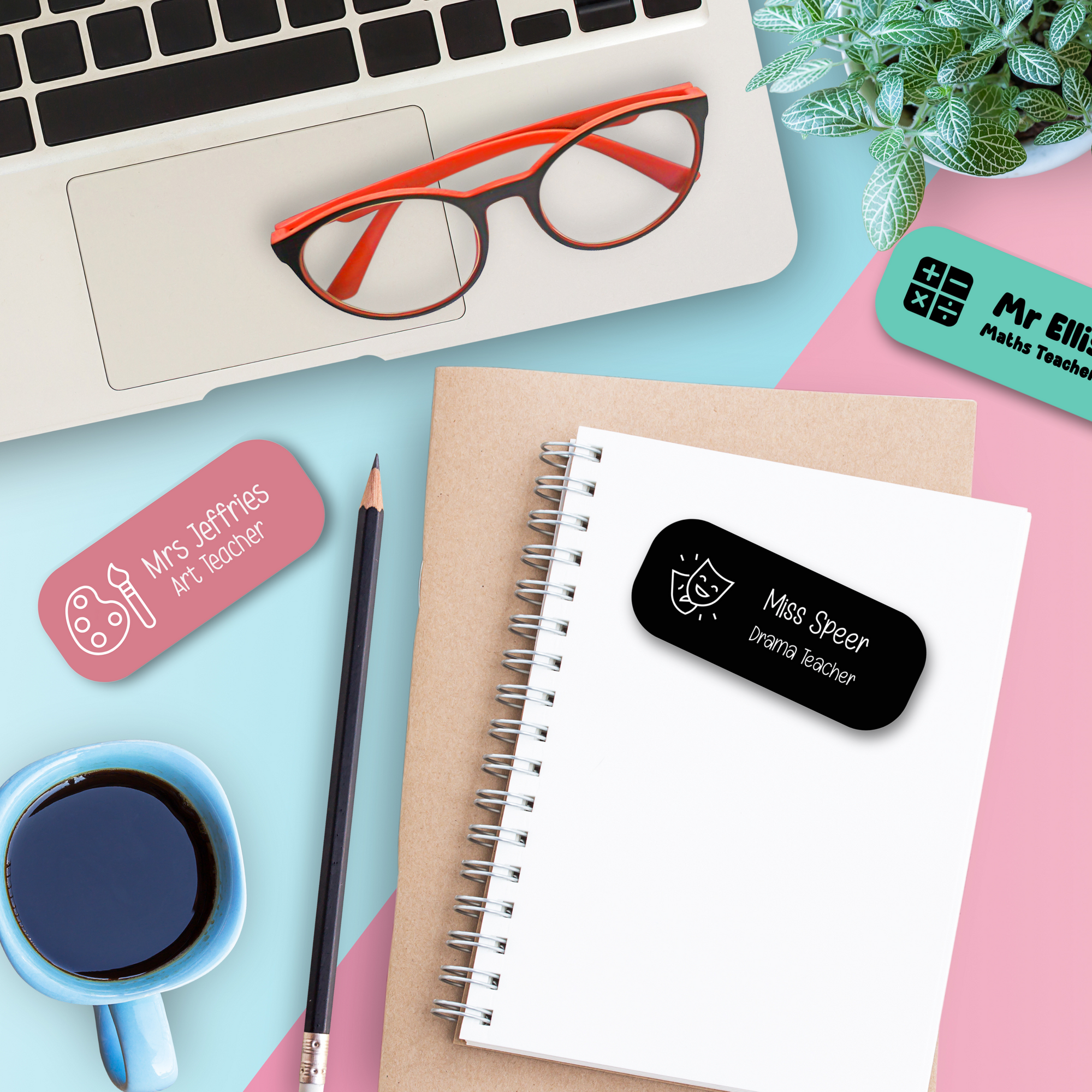 Personalised teacher name badges for drama, art, and maths teachers displayed on desk with laptop, notebook, and coffee. Custom school staff ID tags