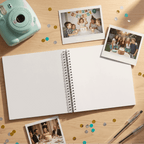 Open album with polaroid photos and a mint green camera on a wooden surface with confetti.