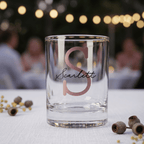 Clear glass with 'Scarlett' monogram on a blurred outdoor setting