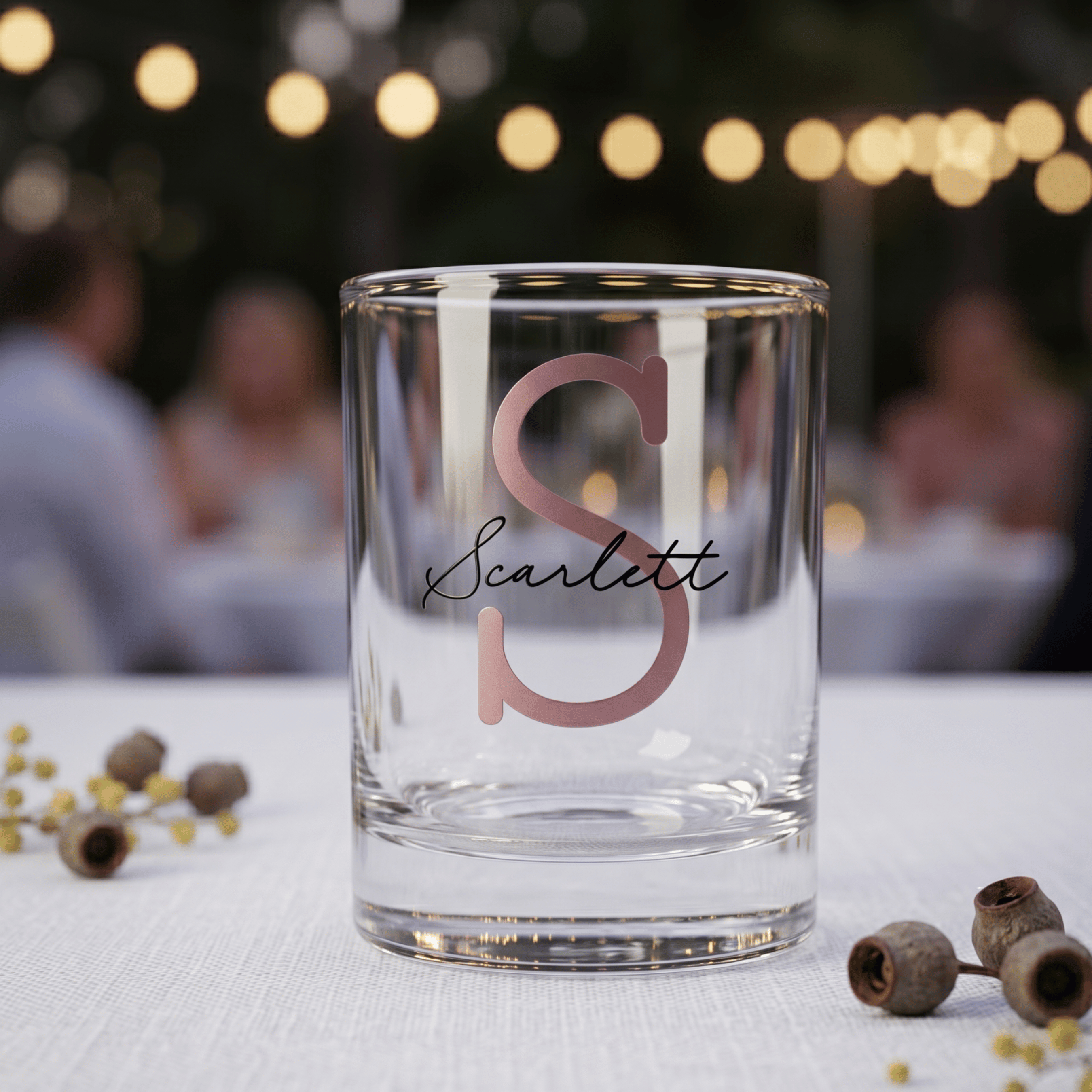 Clear glass with 'Scarlett' monogram on a blurred outdoor setting