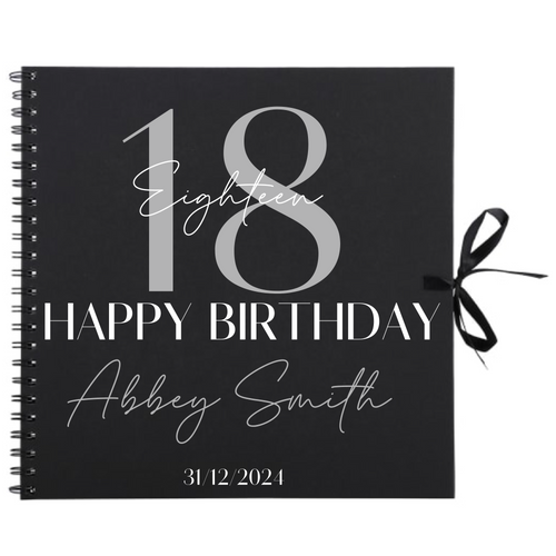Close-up of 18th birthday personalised scrapbook album in black with ribbon tie, name and date on cover
