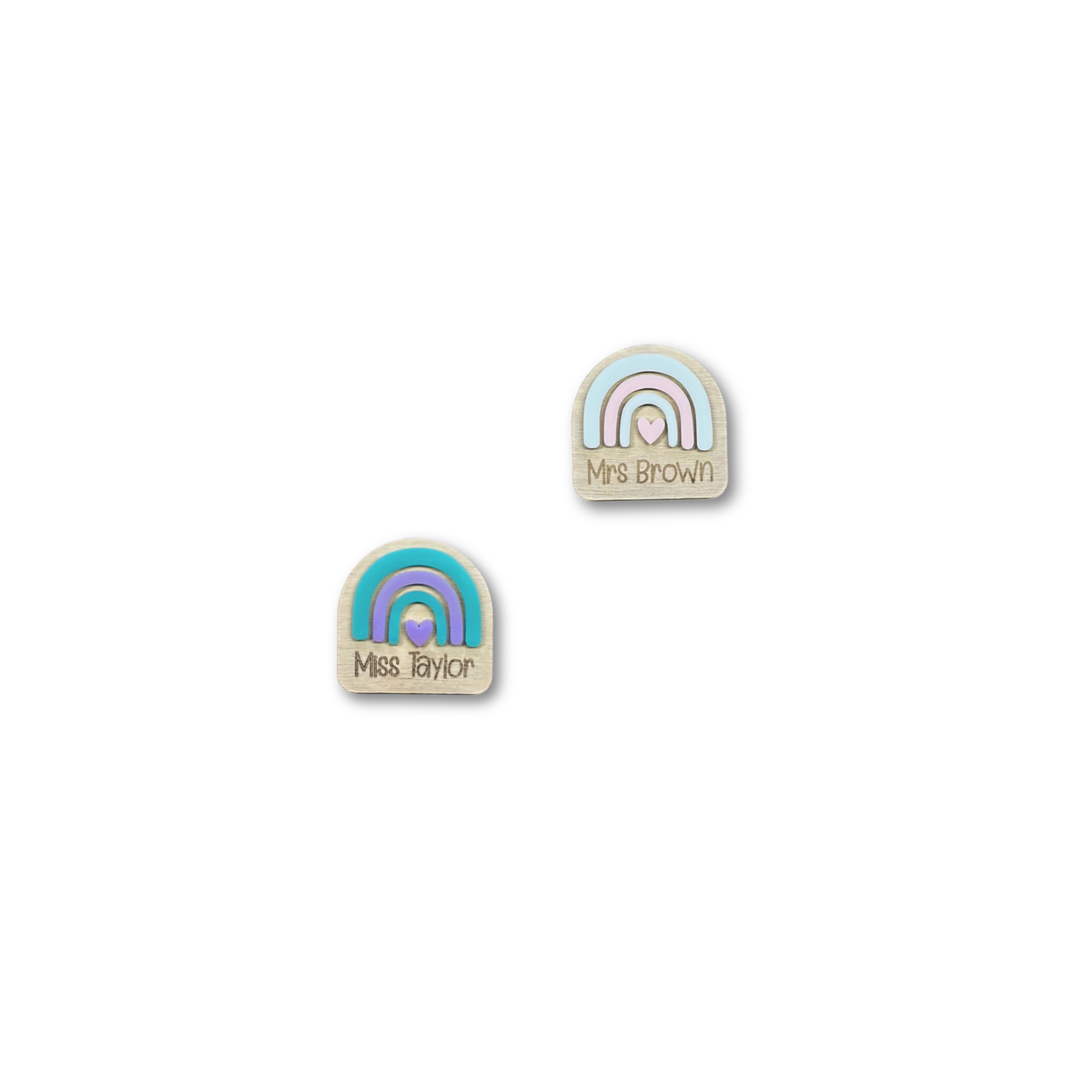 Flat lay of two rainbow name badges with engraved teacher names
