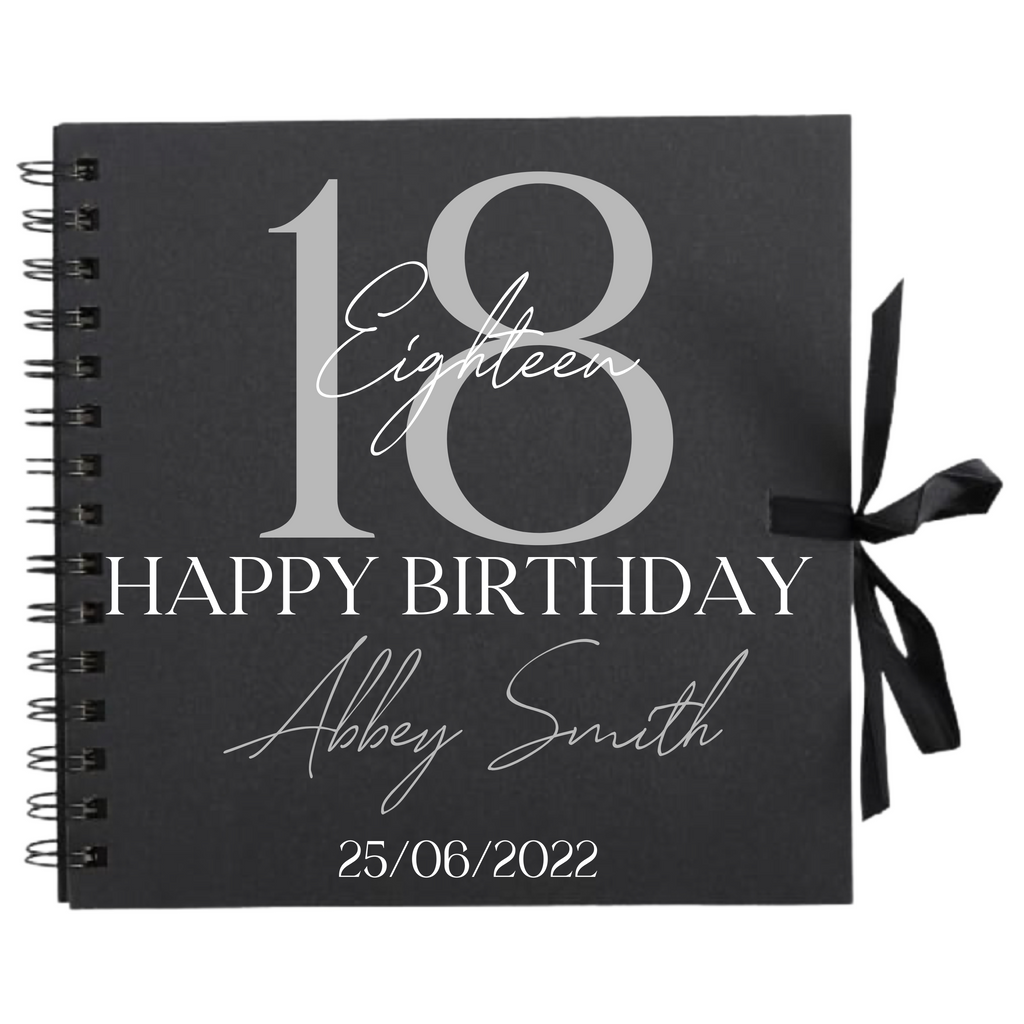 Close-up of 18th birthday personalised scrapbook album in black with ribbon tie, name and date on cover