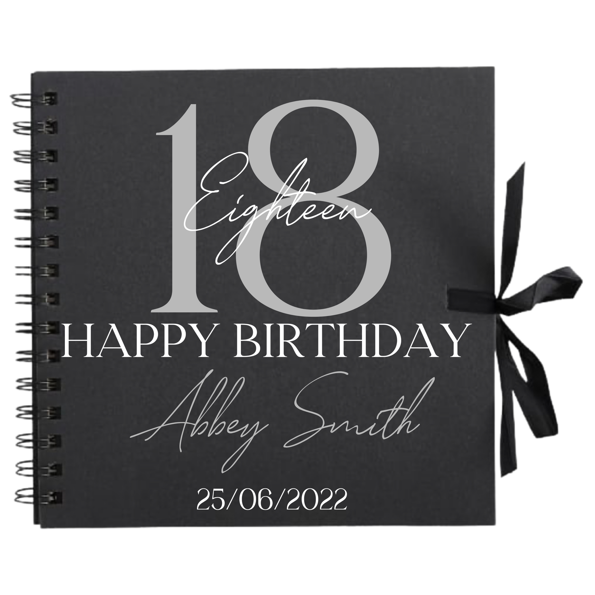 Close-up of 18th birthday personalised scrapbook album in black with ribbon tie, name and date on cover