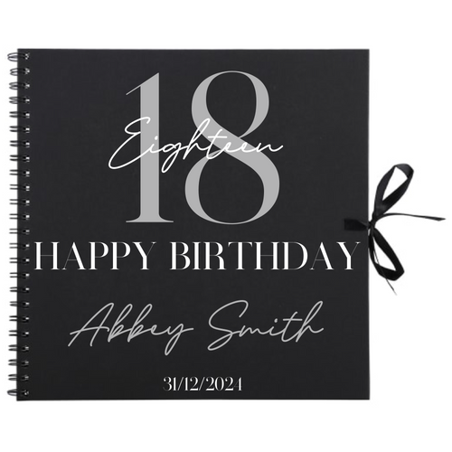 Close-up of 18th birthday personalised scrapbook album in black with ribbon tie, name and date on cover