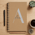 Brown notebook with 'Ava' on a wooden surface with stationery items.