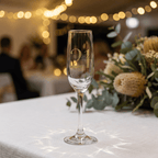 Champagne flute with '21' and 'Issabella' text on a table with blurred background