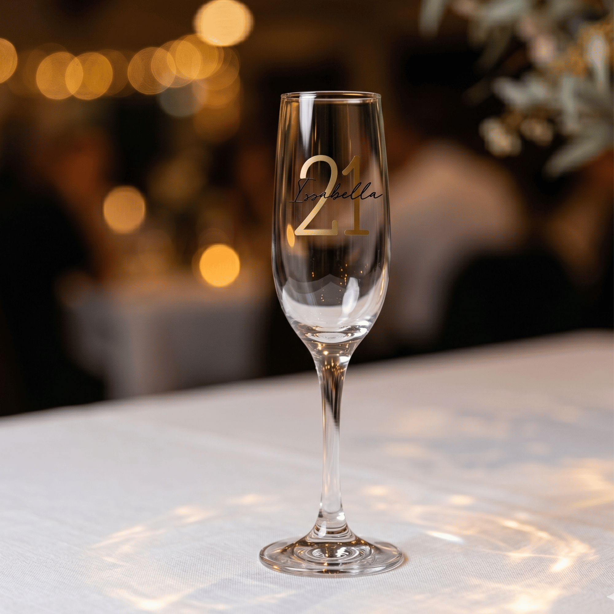 Champagne flute with '21' and 'Natalia' text on a blurred background