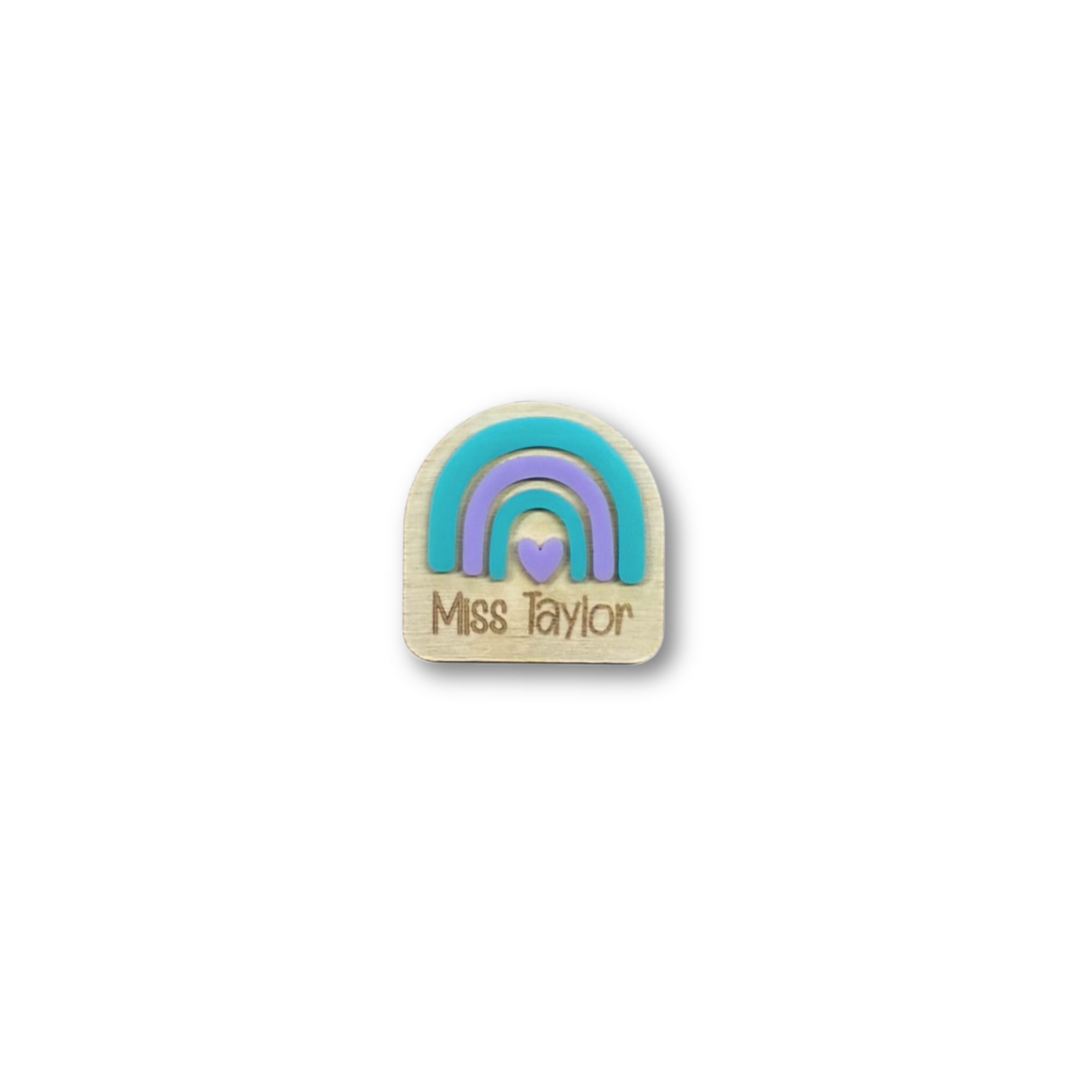 Close-up of custom rainbow name badge engraved with Miss Taylor