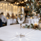 Champagne flute with '21 Isabella' on a table with blurred background