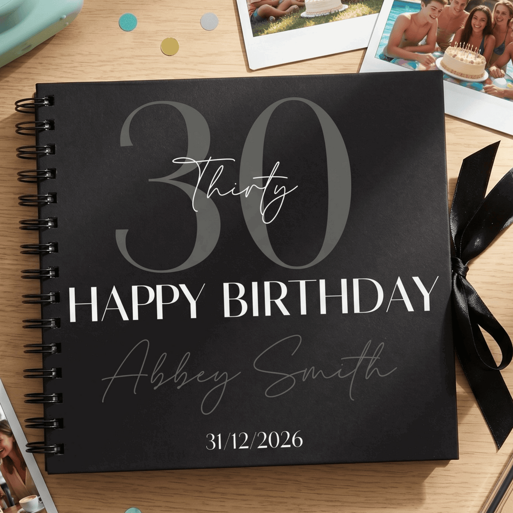 Black Album with '30 Happy Birthday Abbey Smith 31/12/2026' on a wooden surface with photos and ribbons.