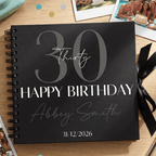 Black Album with '30 Happy Birthday Abbey Smith 31/12/2026' on a wooden surface with photos and ribbons.