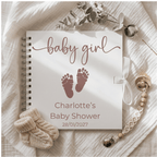 Baby shower guest book with 'baby girl' text and footprints on a soft fabric background.