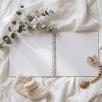 Open Album with baby booties and a pacifier on a soft fabric background