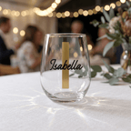 Clear glass with 'Isabella' printed on it, placed on a table with blurred background