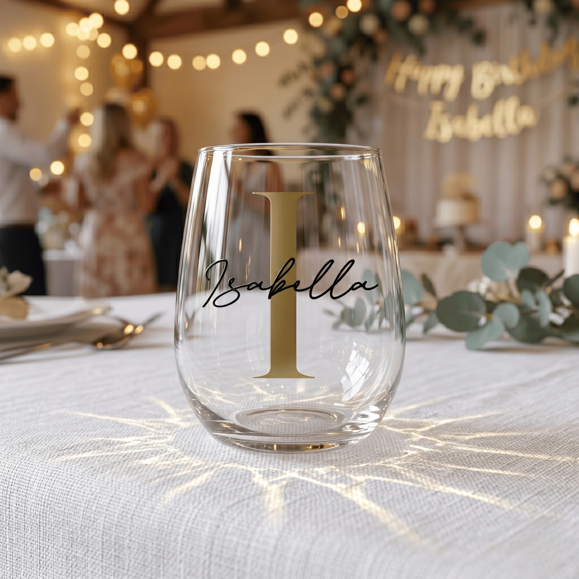 Clear glass with 'Isabella' on a tablecloth at a festive event