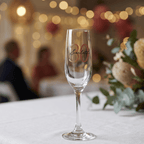 Champagne flute with '30 Scarlett' text on a blurred festive background