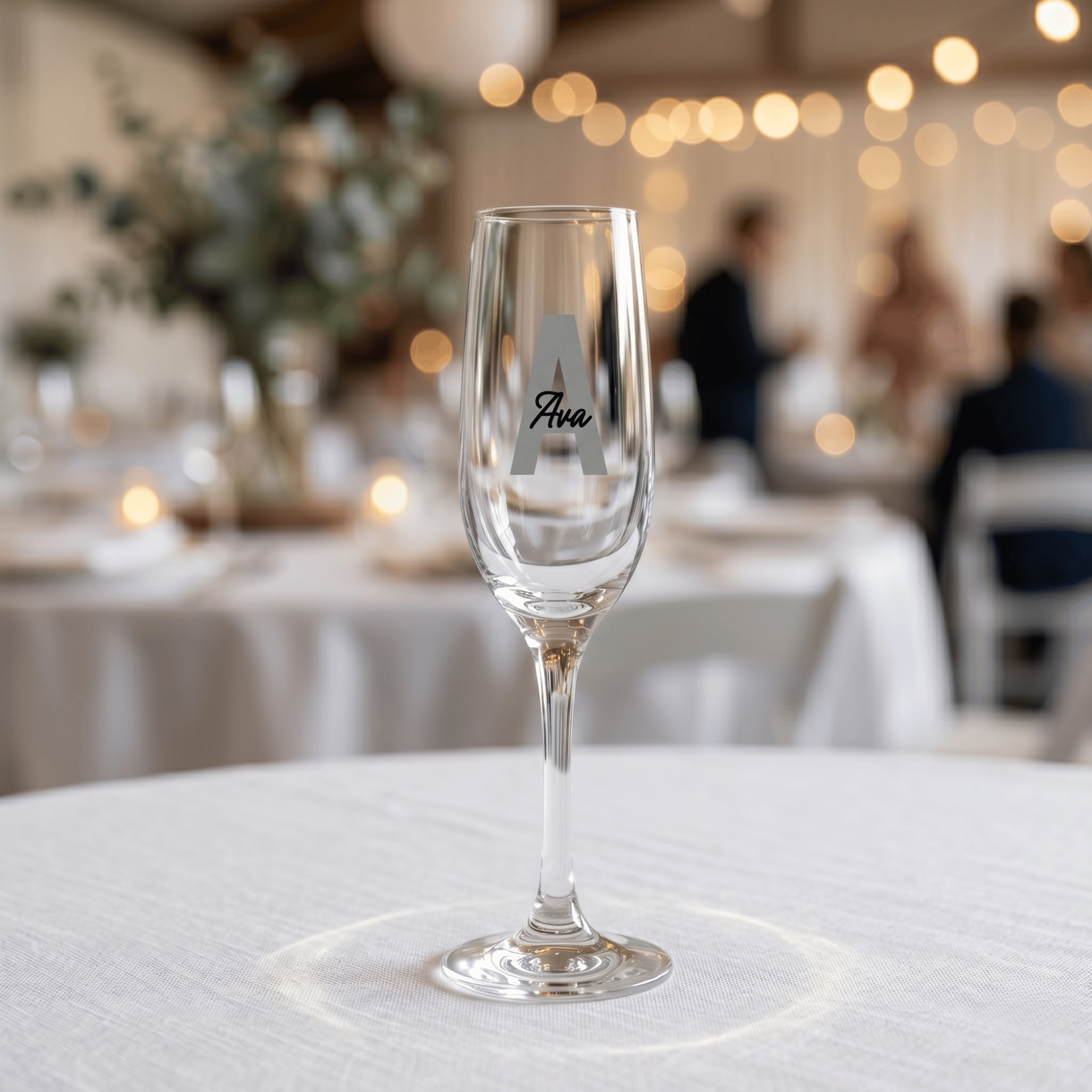 Clear glass with 'Ava' branding on a tablecloth-covered table in a softly blurred restaurant setting.