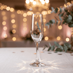 Clear champagne flute with 'Ava' engraving on a blurred festive background