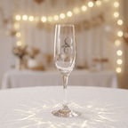 Champagne flute with number 8 on a tablecloth with fairy lights in the background