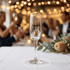 Champagne flute with 'Isabella' on a table with blurred people and lights in the background