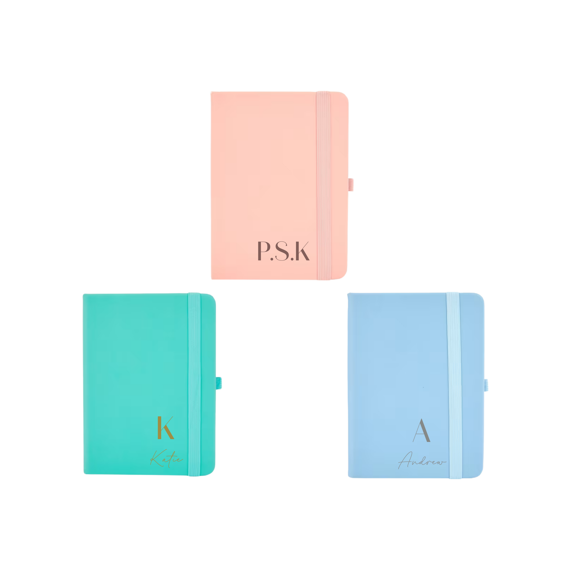 Flat lay of three personalised A6 vegan leather notebooks in pastel peach, teal, and blue colours with custom initials and names on covers.