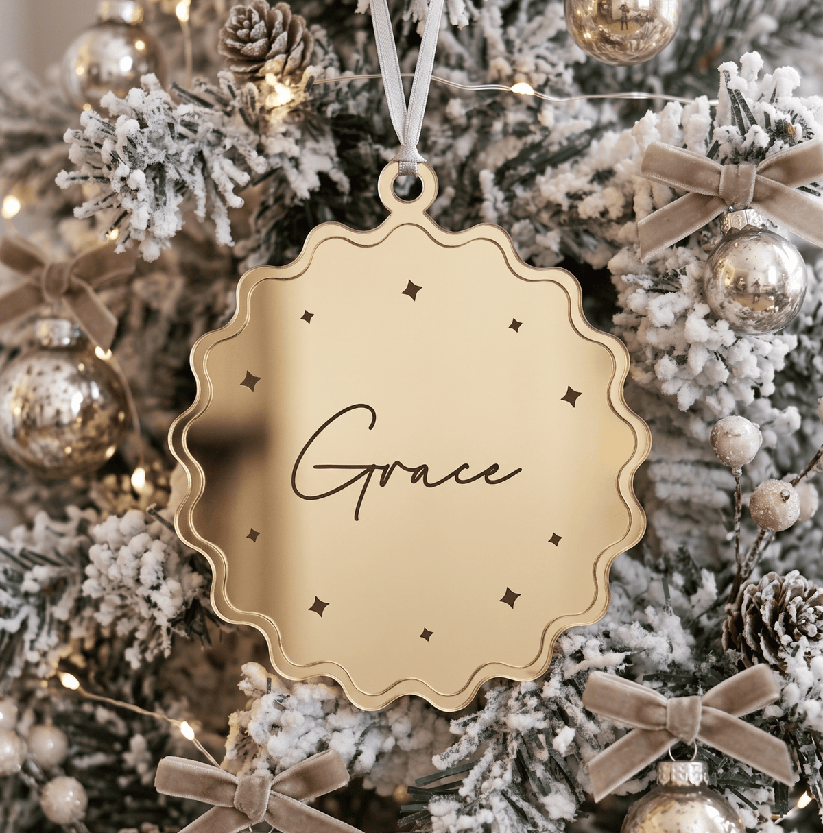 Close up view of custom 3D layered Christmas tree ornament showing precise laser cut name details and smooth timber texture