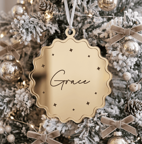 Close up view of custom 3D layered Christmas tree ornament showing precise laser cut name details and smooth timber texture
