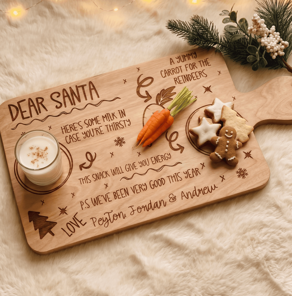 Personalised Christmas Eve Santa treat board engraved with family name holding milk and cookies on a wooden table