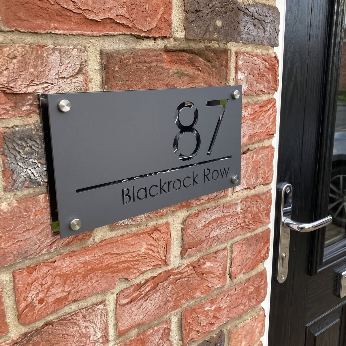 Dual layer charcoal and mirror acrylic address sign with cut out numbers installed on red brick using four corner stand offs.