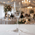 Custom engraved champagne glass for a Maid of Honour named Charlotte, featuring vertical script text on a crystal-clear flute at a luxury wedding reception.