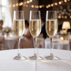 Three champagne glasses with personalised inscriptions on a table with blurred background