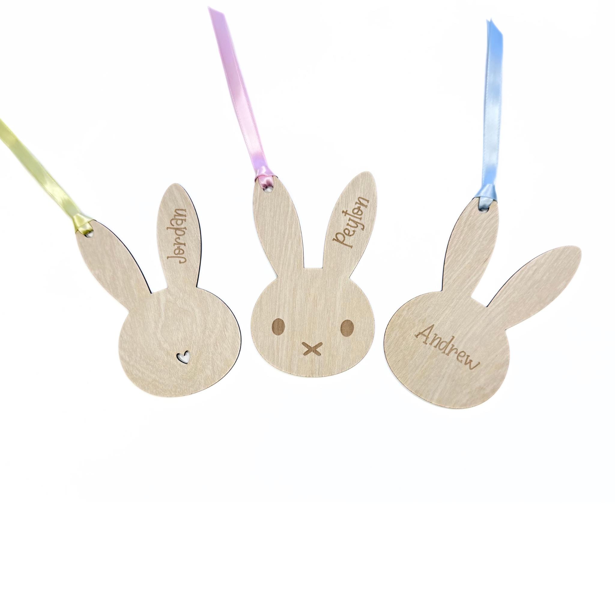Set of three engraved wooden bunny Easter tags with pastel ribbons – names Jordan, Peyton, and Andrew with heart, face, and plain designs.