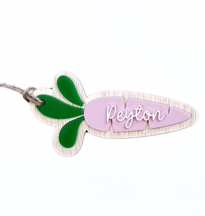 Wide angle of pink carrot Easter name tag with green leaves and twine – personalised with name "Peyton".