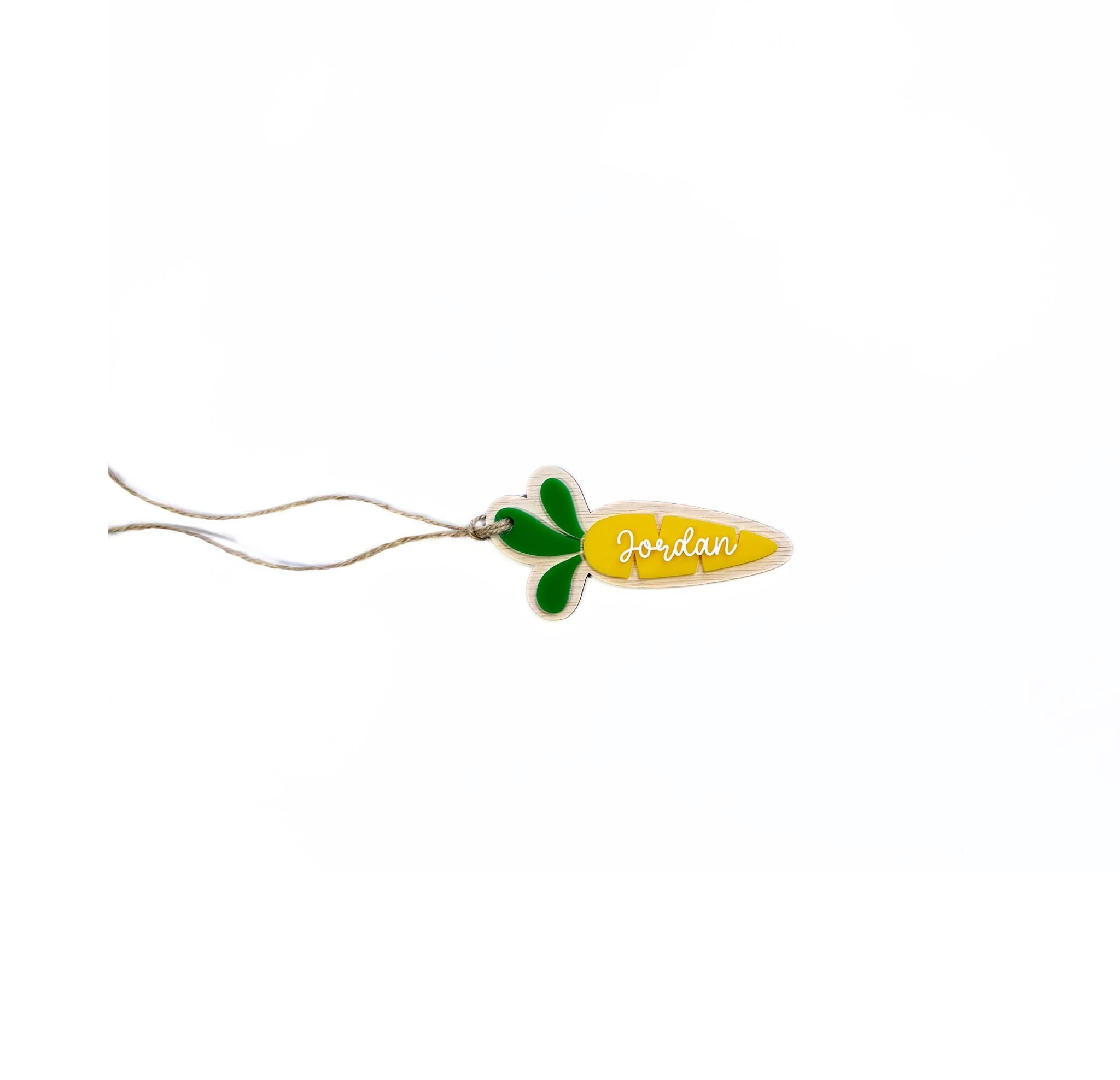 Personalised carrot Easter basket tag in yellow with name "Jordan" – custom name tag with green leaves and twine loop.