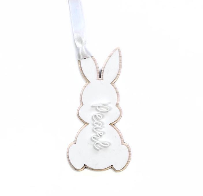 White acrylic Easter bunny-shaped name tag with “Pearl” in raised white lettering – personalised Easter basket tag with satin ribbon