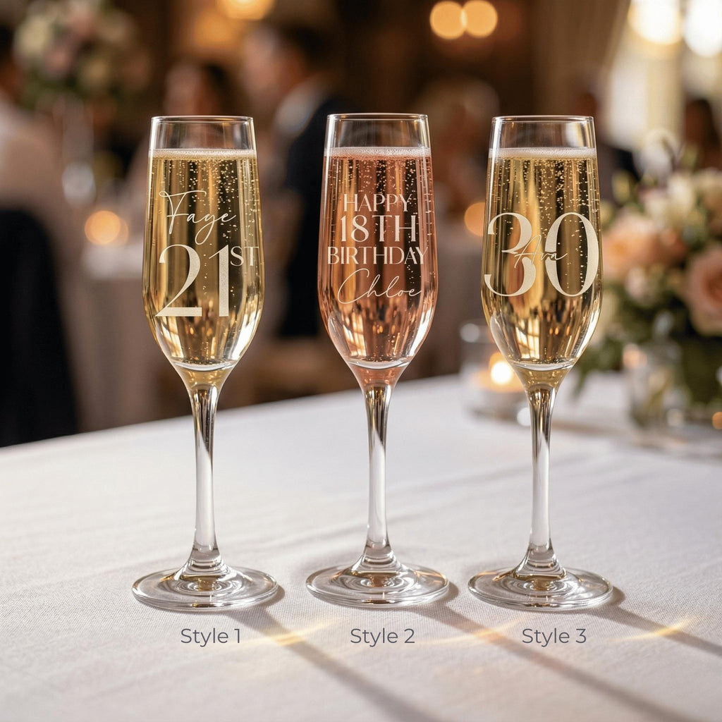 Three champagne flutes with personalised inscriptions on a tablecloth.