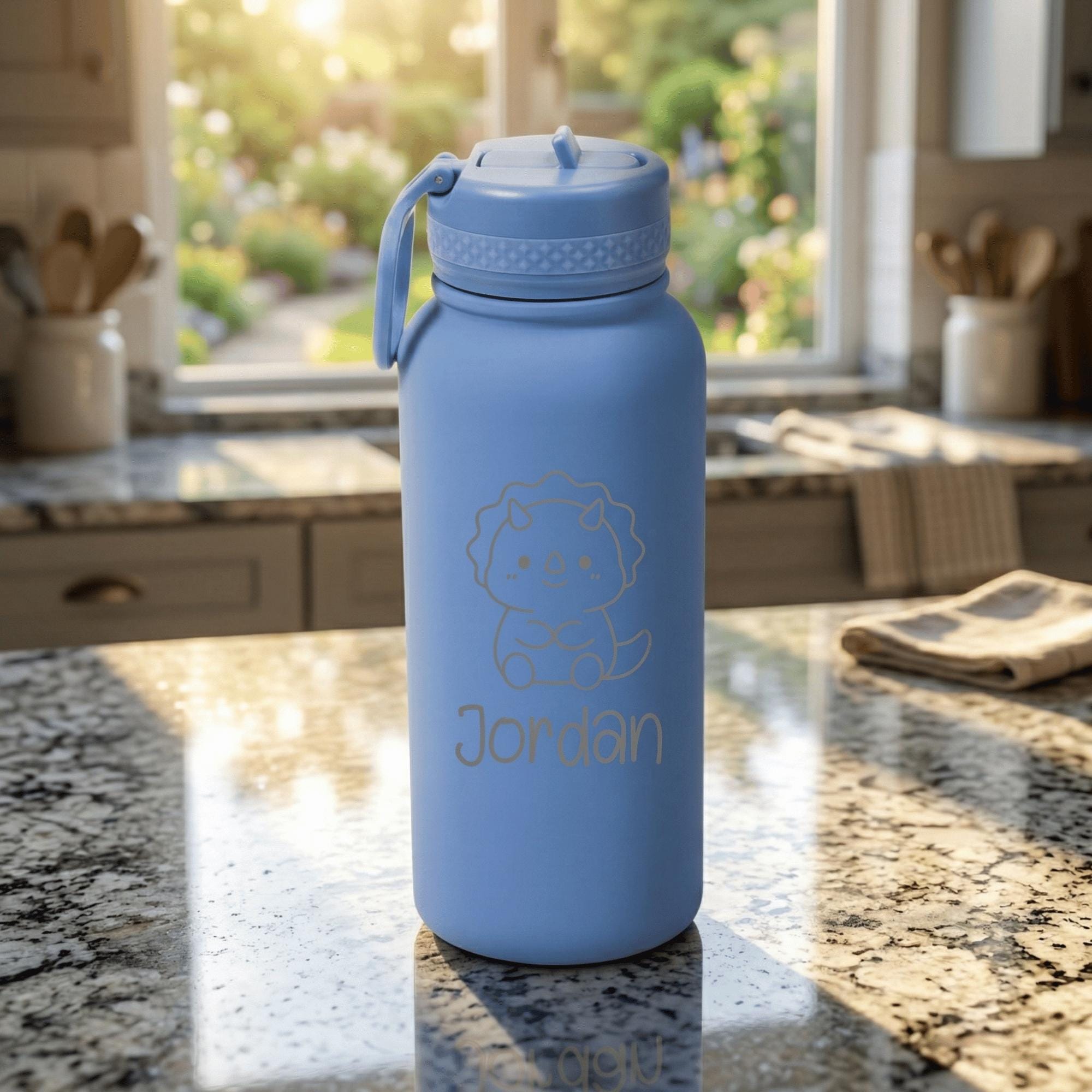 Blue water bottle with a cat illustration and 'Jordan' text on a kitchen counter.