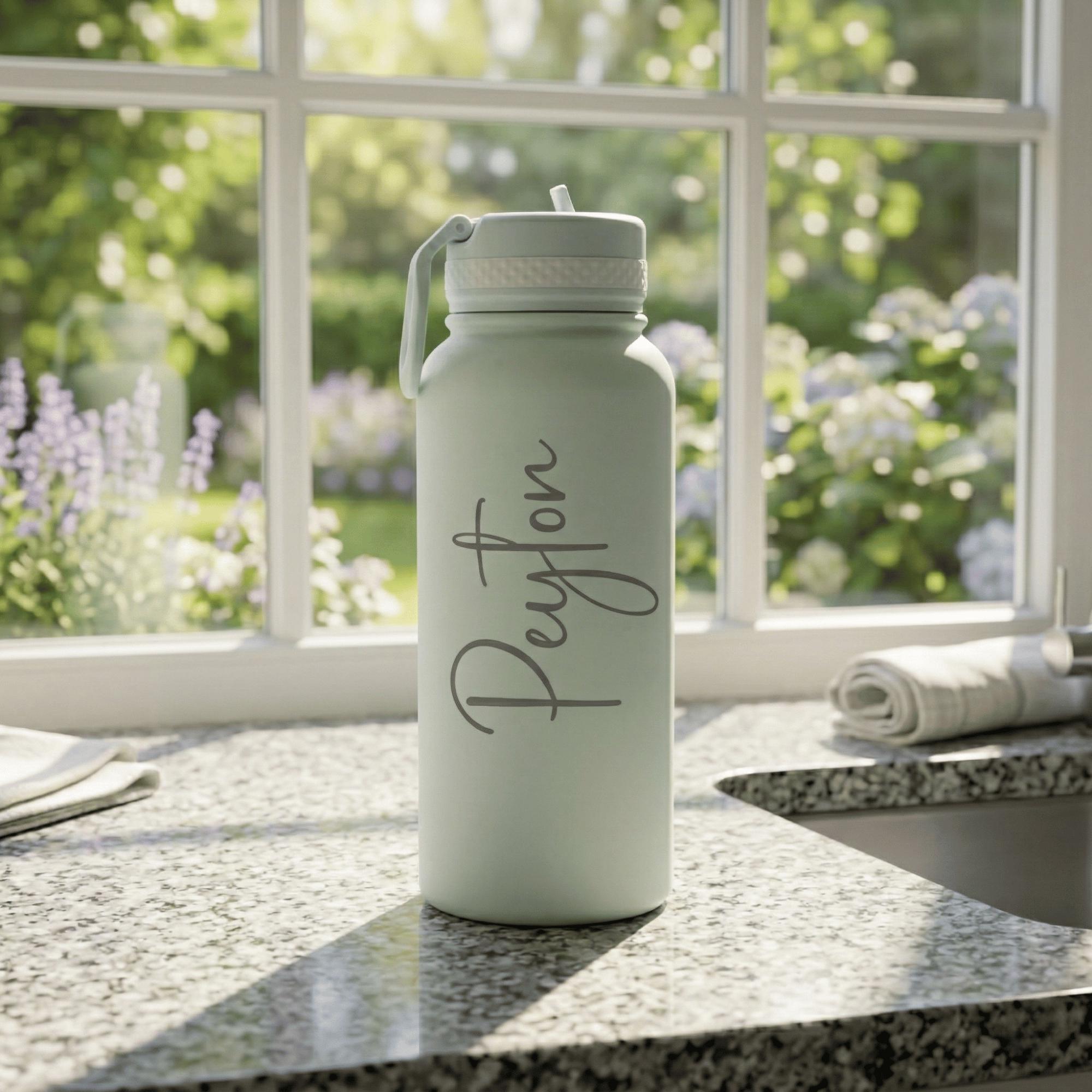 Light green water bottle with 'Peyton' on a kitchen counter with a window in the background
