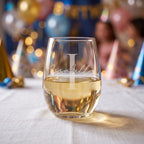 Glass of white wine with 'Issabella' engraving on a festive background
