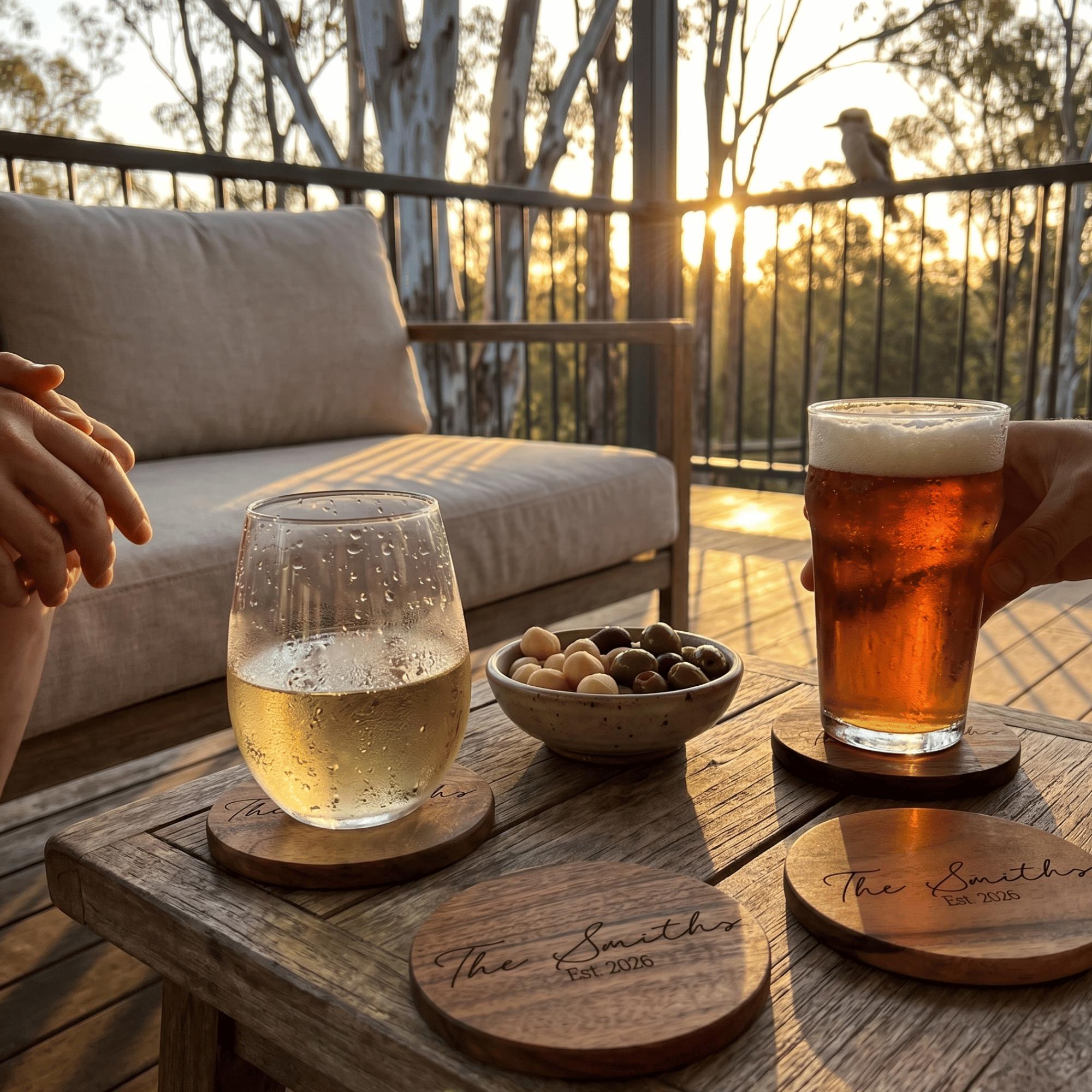 Two glasses of beer and a wine glass on a wooden table with sunset in the background.