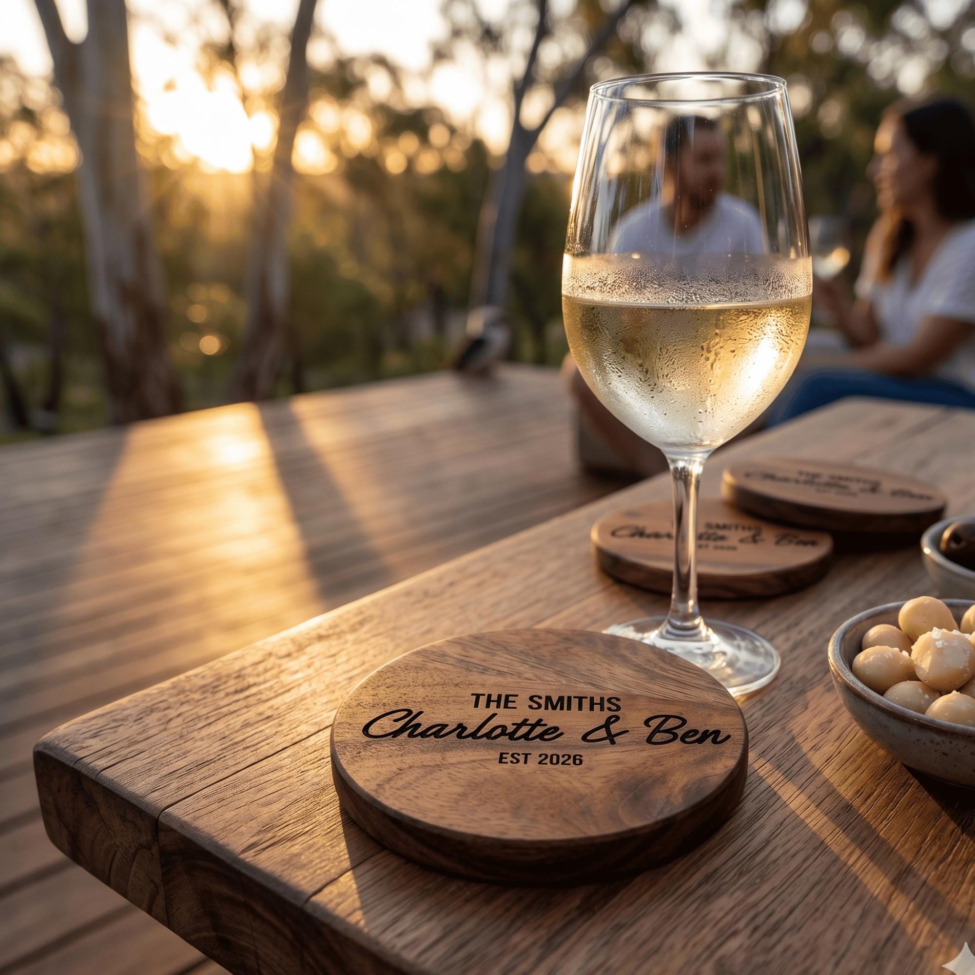 Wine glass with a couple in the background on a wooden table