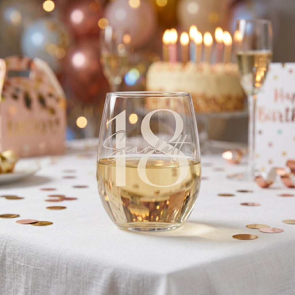 Stemless wine glass with '18 Scarlett' engraving on a birthday celebration table.