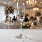 Custom engraved champagne glass for a Maid of Honour named Charlotte, featuring vertical script text on a crystal-clear flute at a luxury wedding reception.